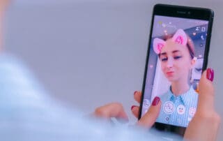 IKIN woman holding smartphone selecting AR filters on selfie photo